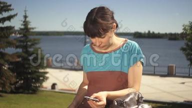 一个年轻的女人在一个坐在海滨的玩具旋转器手中扭动。